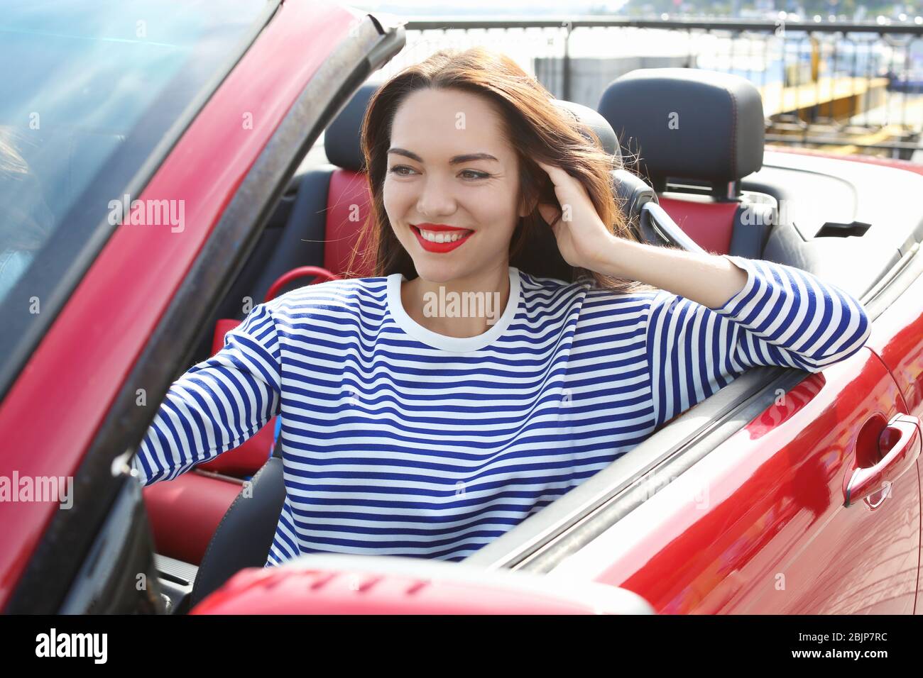 Schöne junge Frau im Cabrio draußen Stockfoto