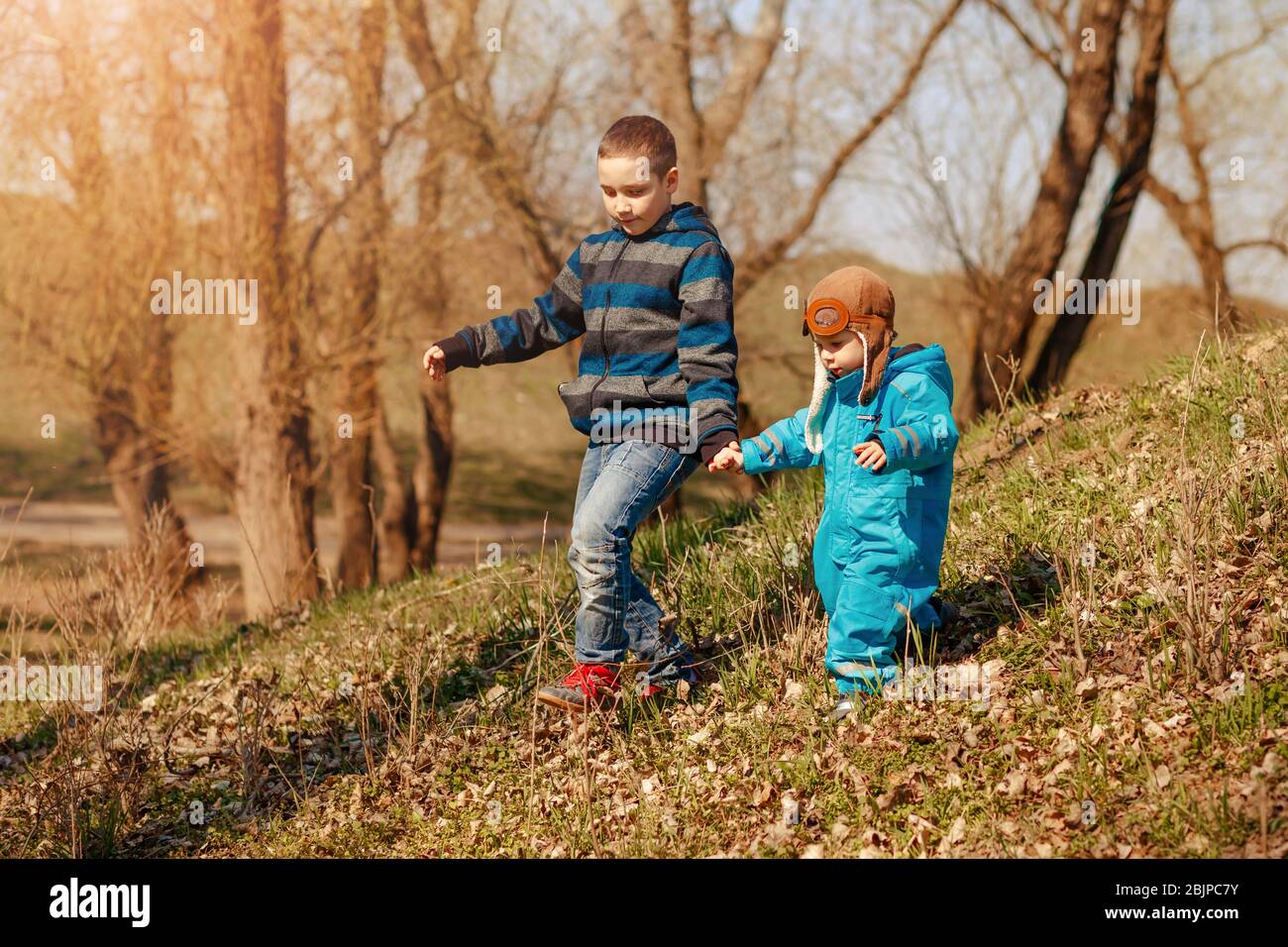 Glückliche Kinder auf dem Spaziergang im sonnigen Wald oder Park. Aktivitäten im Freien Stockfoto