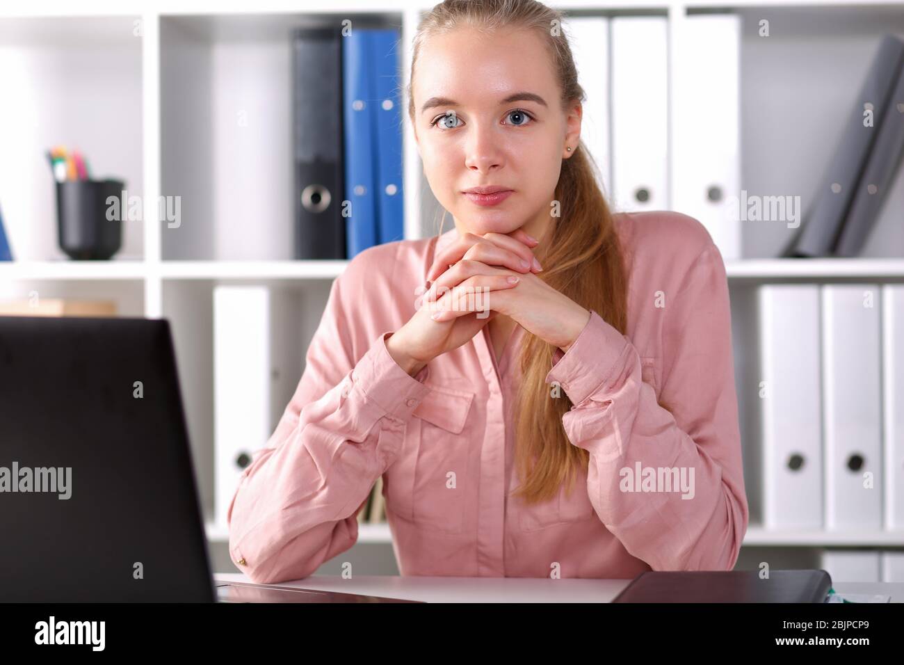 Mädchen sitzt im Büro vor Laptop Stockfoto