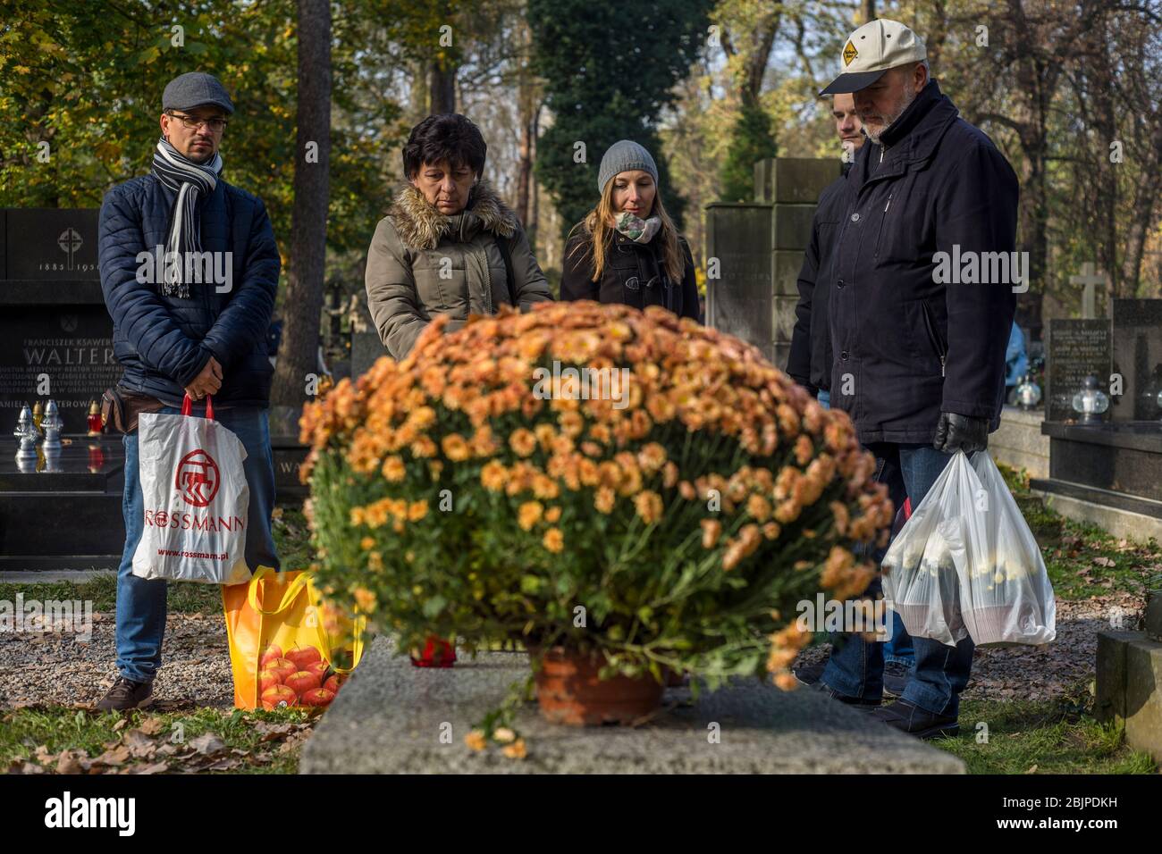 Eine Familie erinnert sich an einen verstorbenen Angehörigen auf dem Rakowicki-Friedhof in Krakau, Polen 2019. Stockfoto