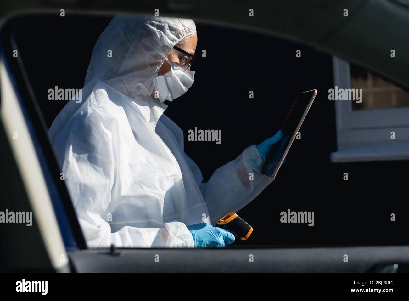 Kaukasische Frau trägt einen Labor Overall und Coronvirus covid19 Maske outsdide Stockfoto