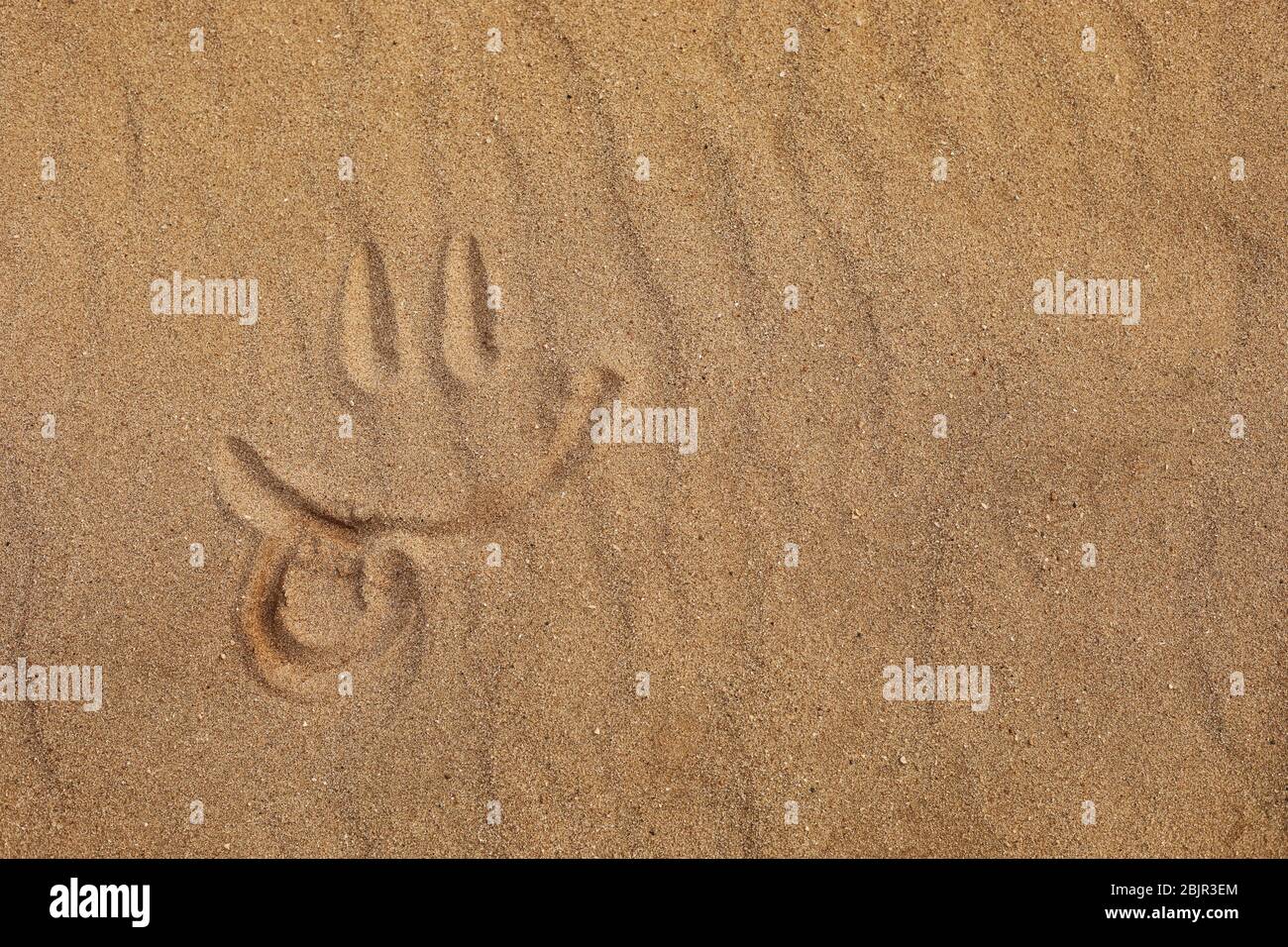 Smiley von Finger auf Sandstrand gemacht - Zunge aus. Selektive Fokussierung Stockfoto