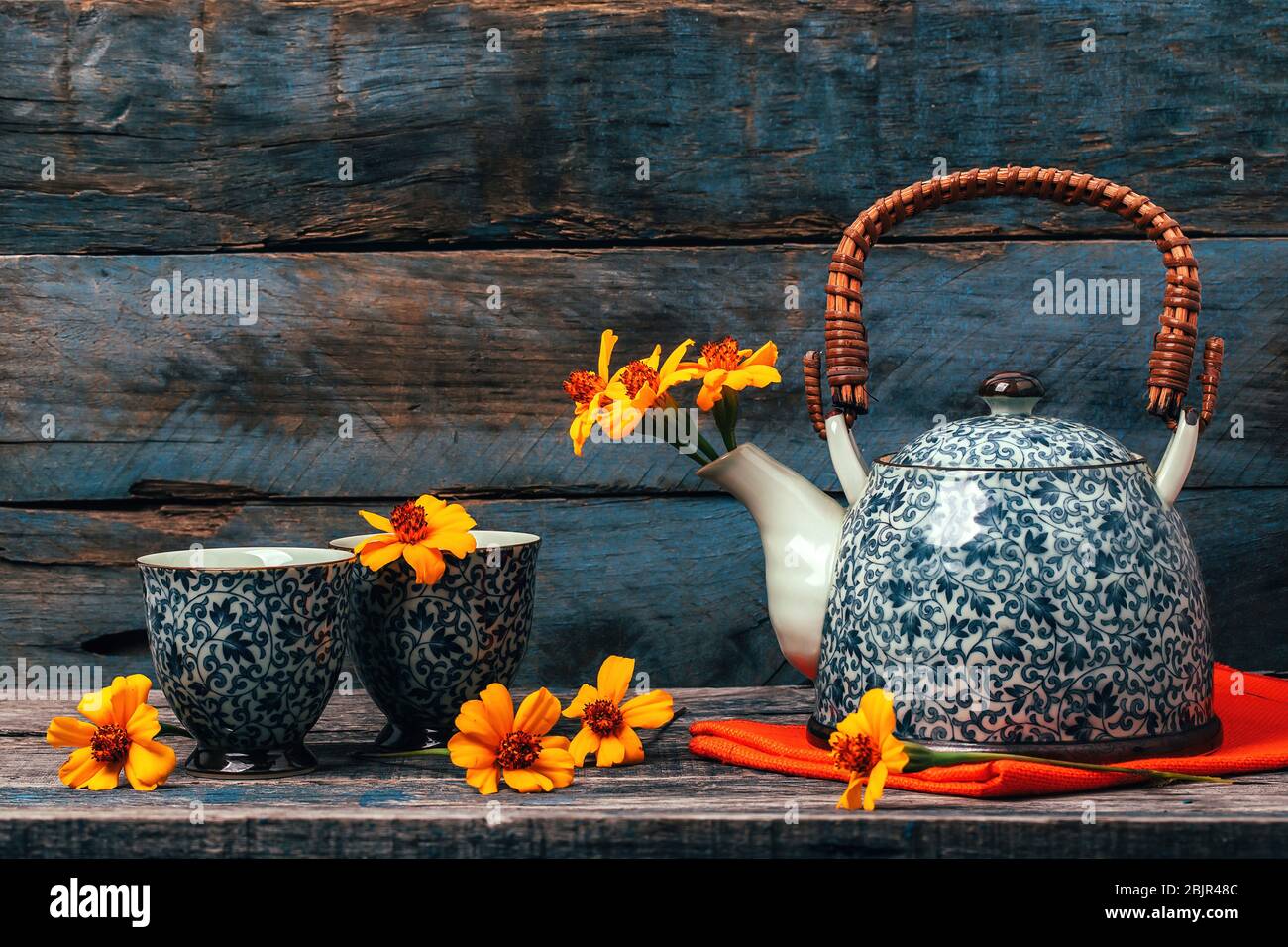 Stillleben mit Chernobrivtsi Blumen in Vintage Teekanne und Tassen auf rustikalem alten Hintergrund. Stockfoto