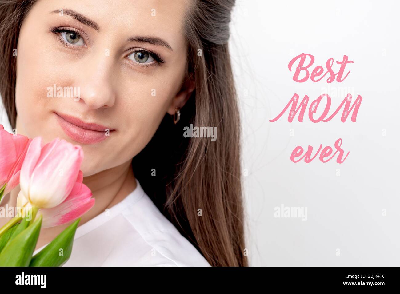 Porträt von schönen lächelnden Frau mit rosa Tulpen auf weißem Hintergrund mit Text Best Mom ever. Stockfoto