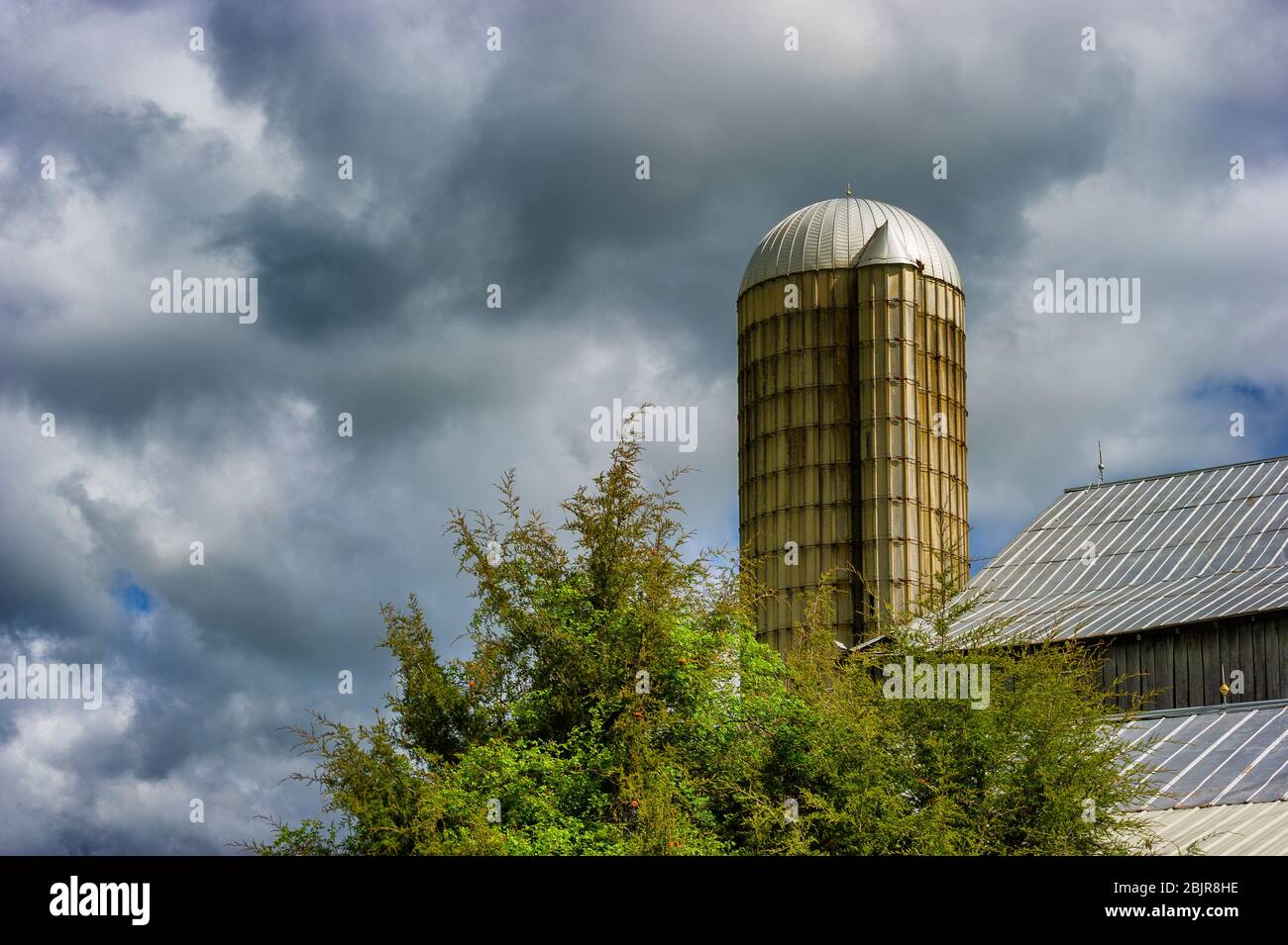 Stürmischer Himmel hängt über einem Silo und einem Dach im ländlichen Tennessee Stockfoto