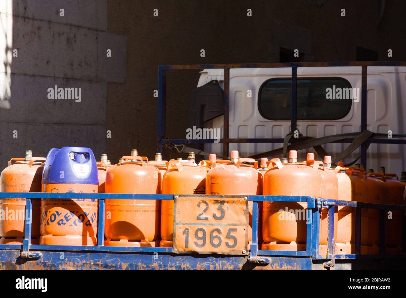 Girona, Spanien - 24. Februar 2020: Orangene Gasflaschen für Kunden im offenen LKW. Lieferung von Gasflaschen in der Stadt. Echte Stadt lif Stockfoto
