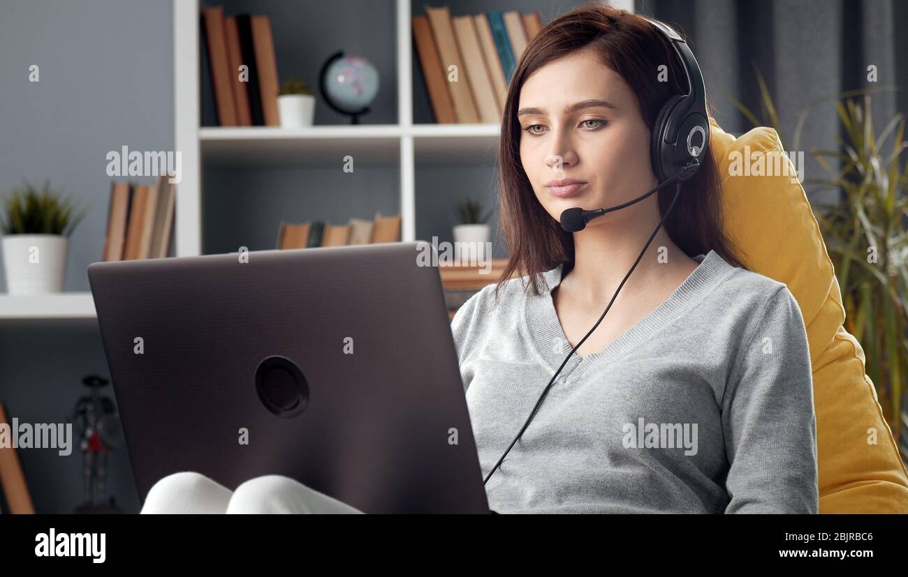 Dame mit Laptop und Headset Stockfoto