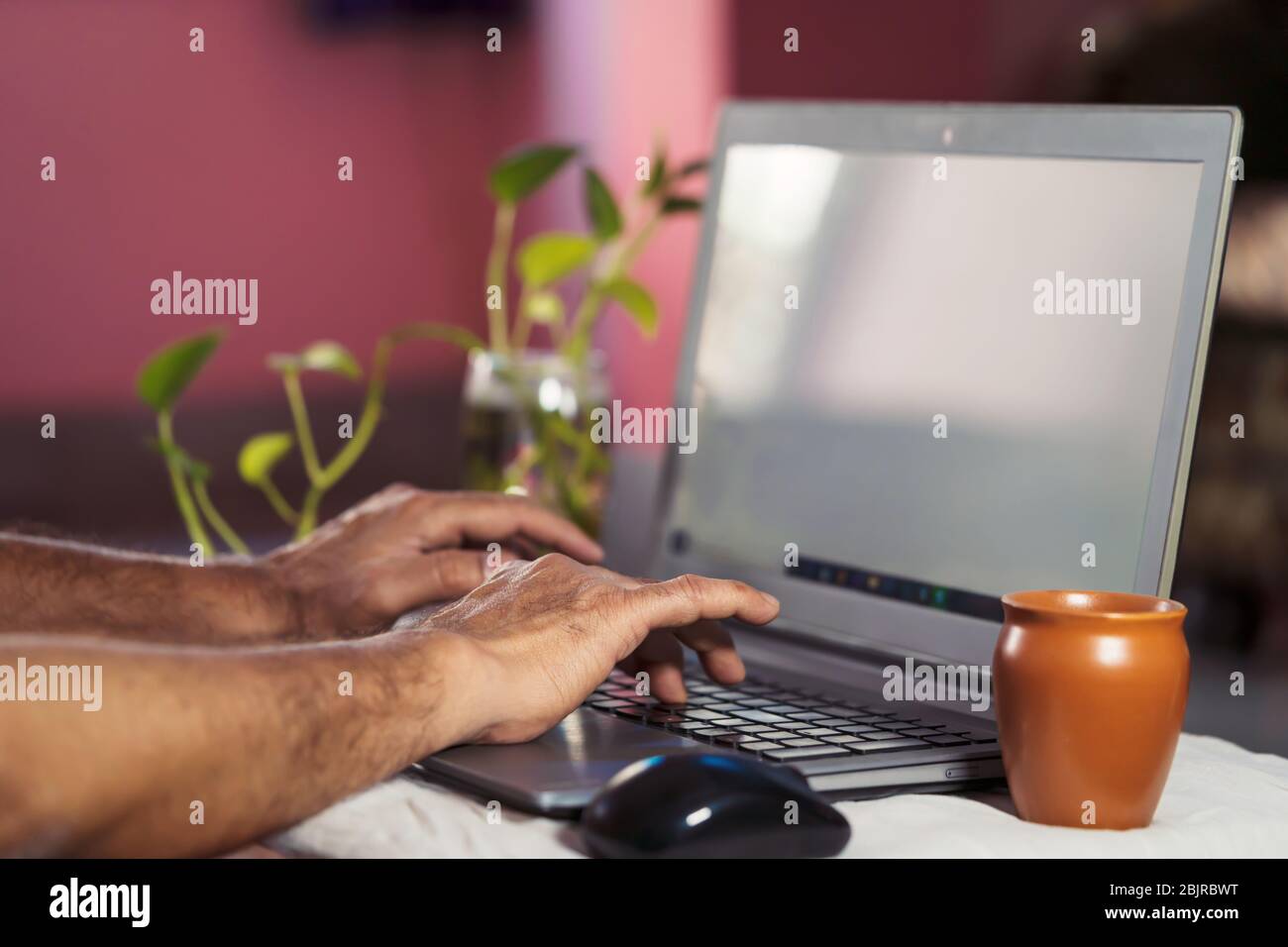 Arbeiten zu Hause Hintergrund. Mann, der zu Hause einen Laptop benutzt oder auf einem Laptop schreibt. Konzept für Quarantäne für Coronavirus, Freiberufler, Smart Business, Social Distanci Stockfoto