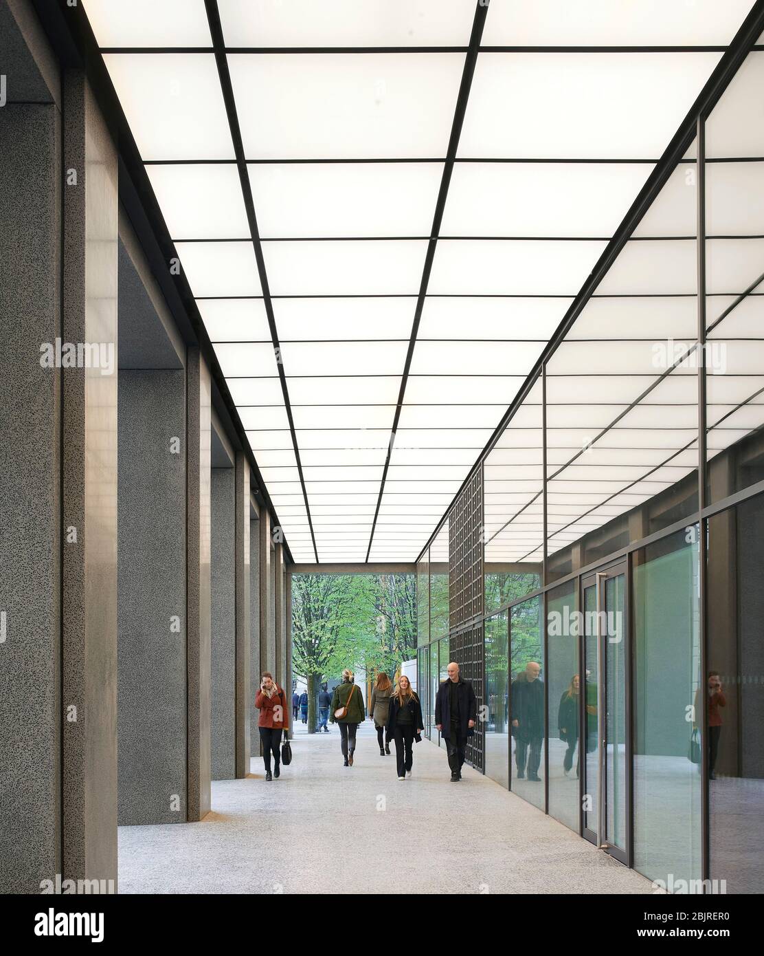 Kolonnade zum Empfangsbereich für Unternehmen mit beleuchteter Decke. 25 Cabot Square, London, Großbritannien. Architekt: Carmody Groarke, 2019. Stockfoto