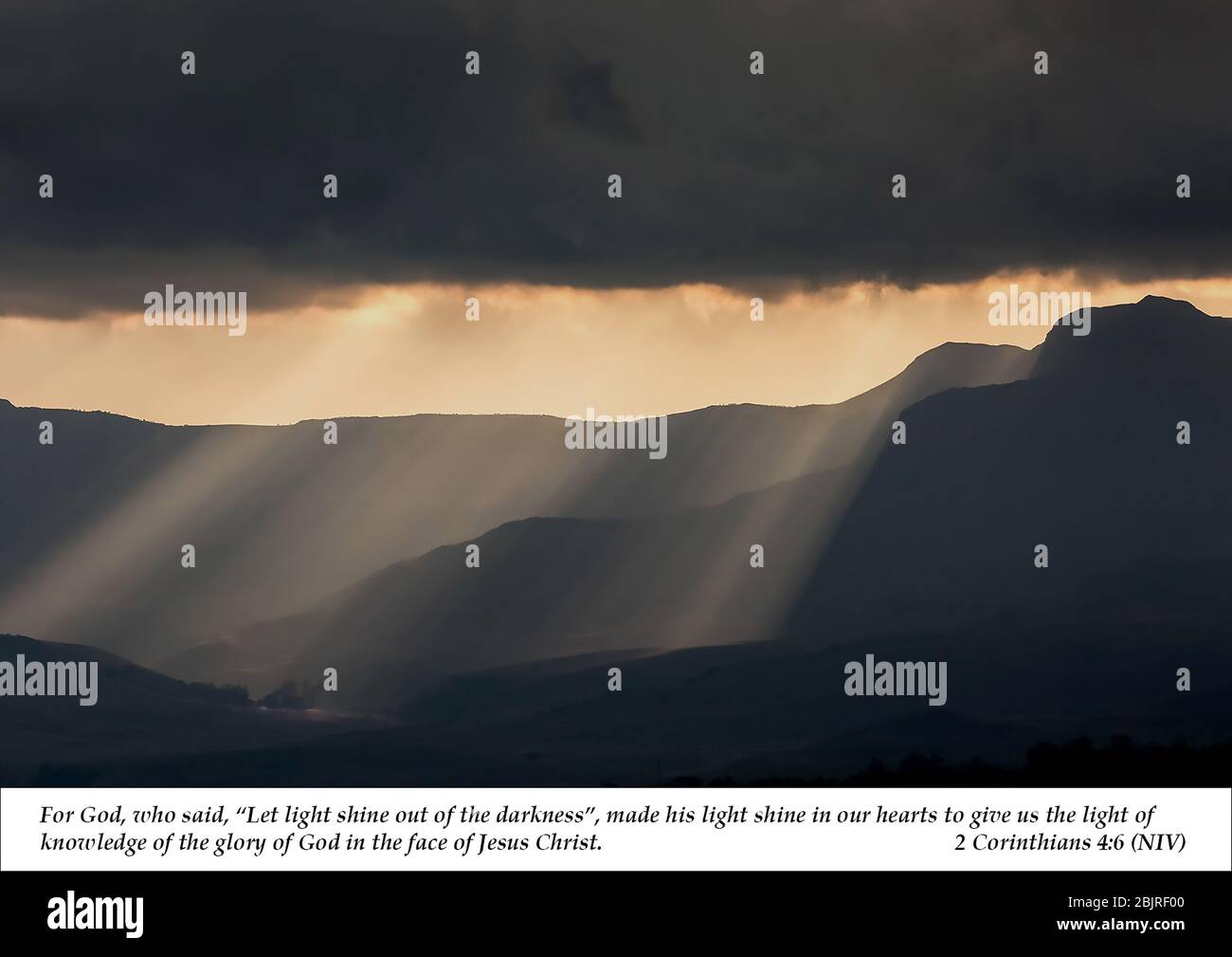 Sonnenstrahlen beleuchten die Berglandschaft durch schwarze Sturmwolken, mit der christlichen Schrift aus 2. Korinther 4,6 aus dem Neuen Testament Stockfoto