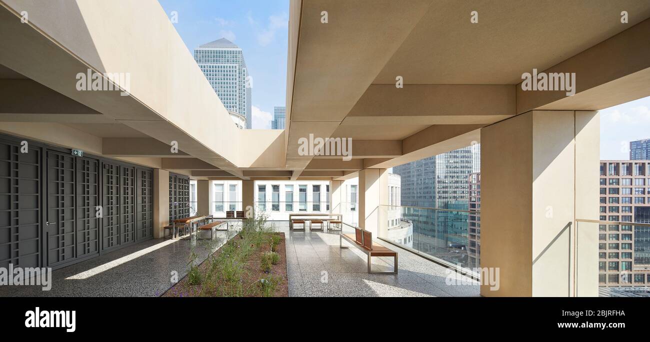 Obere Außenterrasse mit Garten und Blick auf 1 Canada Square. 25 Cabot Square, London, Großbritannien. Architekt: Carmody Groarke, 2019. Stockfoto