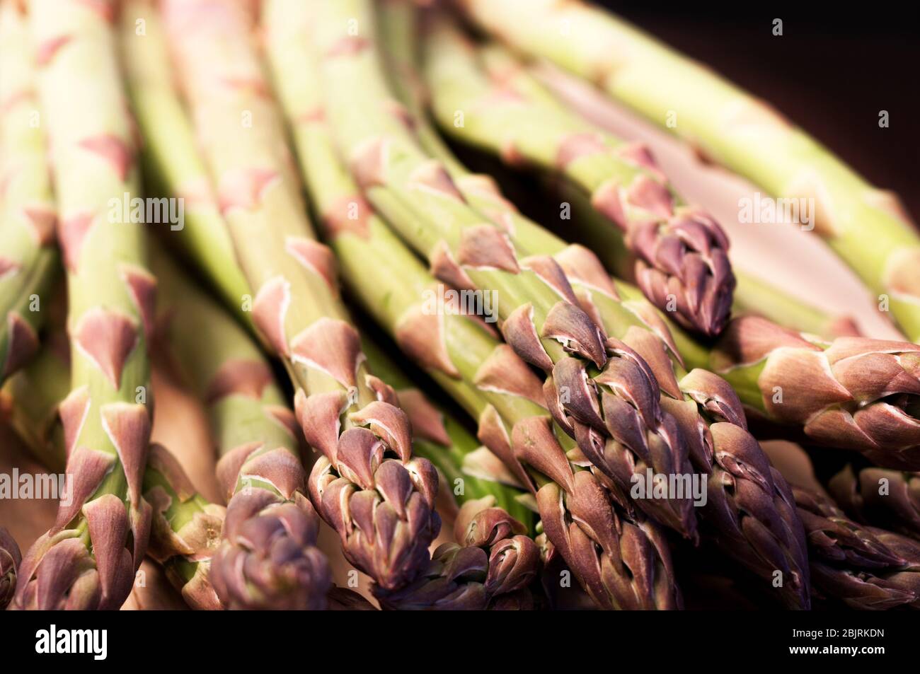 Viele Spargel auf Holzbasis und auf schwarzem Hintergrund. Gesunde Gemüsefutter. studio-Shooting Stockfoto