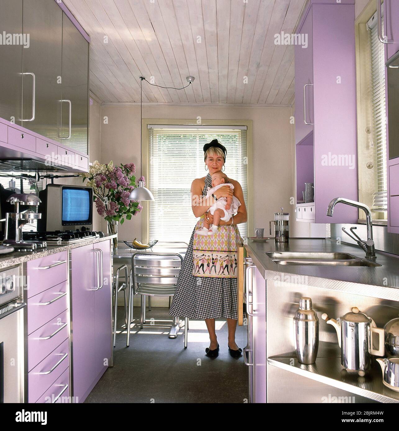 Frau mit Baby in einer Retro-Küche Stockfoto