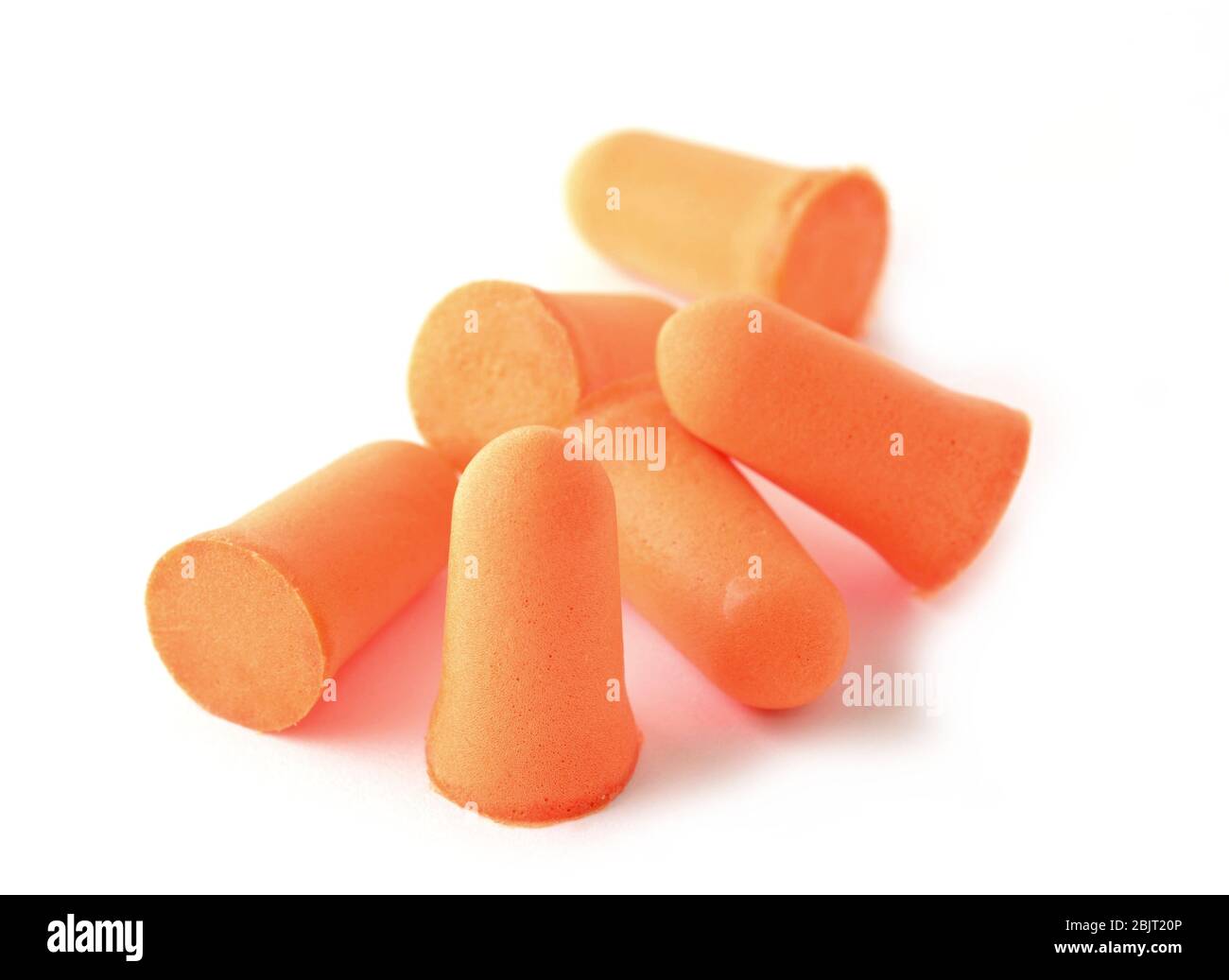 Haufen weicher Schaumstoff orange Ohrstöpsel auf weißem Hintergrund. Stockfoto