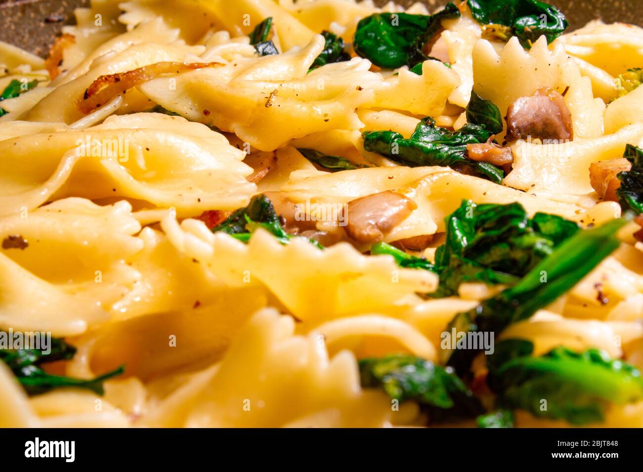 Butterfly Pasta mit gebratenen Pilzen, grünem Spinat Stockfoto