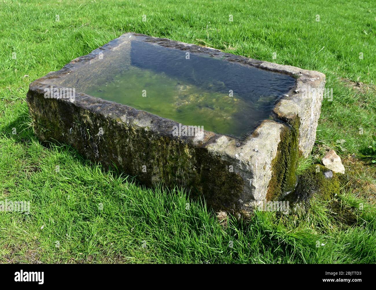Alte steinerne Trinkrinne auf einer natürlichen Quelle gebaut. Stockfoto