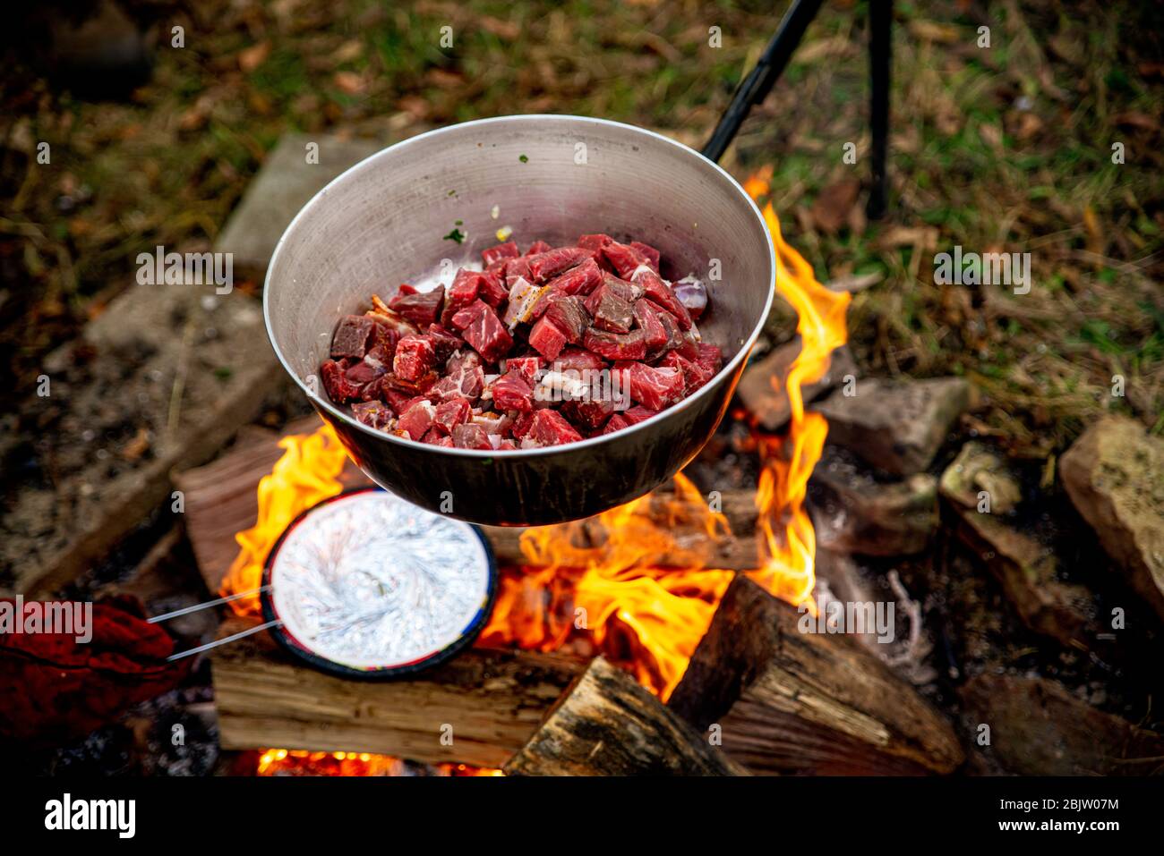 Kochen über einem Lagerfeuer mit geschmorten Speisen Stockfoto