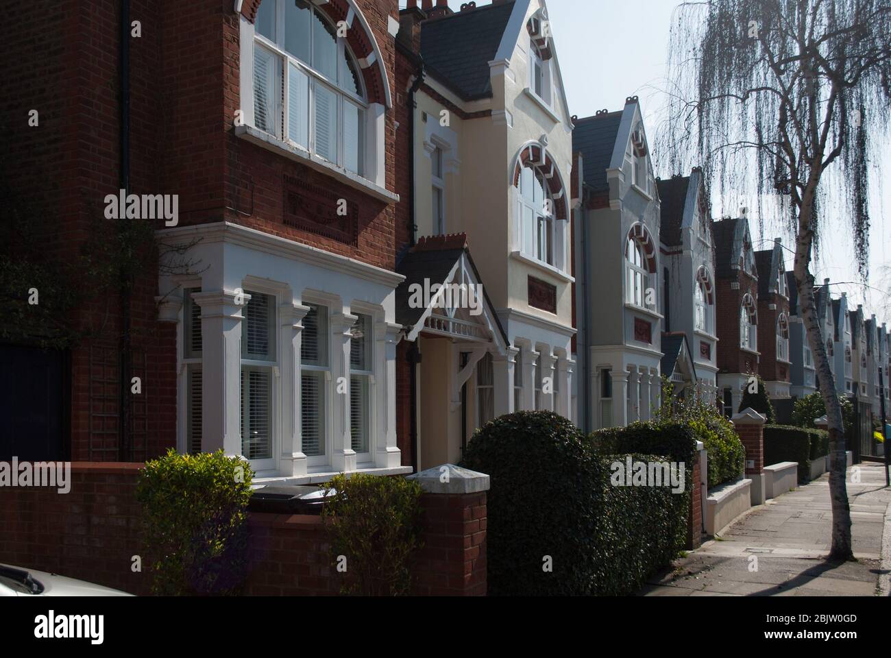 Bunte viktorianische Reihenhäuser mit terassenförmig angelegtem Gehäuse Gelb-Roter Backstein Klassisches traditionelles Straßenmuster auf der Airedale Avenue, Chiswick, London W4 Stockfoto