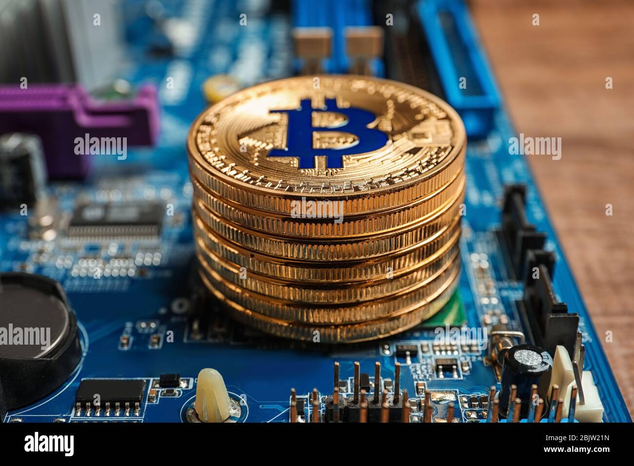 Goldene Bitcoins auf PC-Mainboard, Nahaufnahme Stockfoto