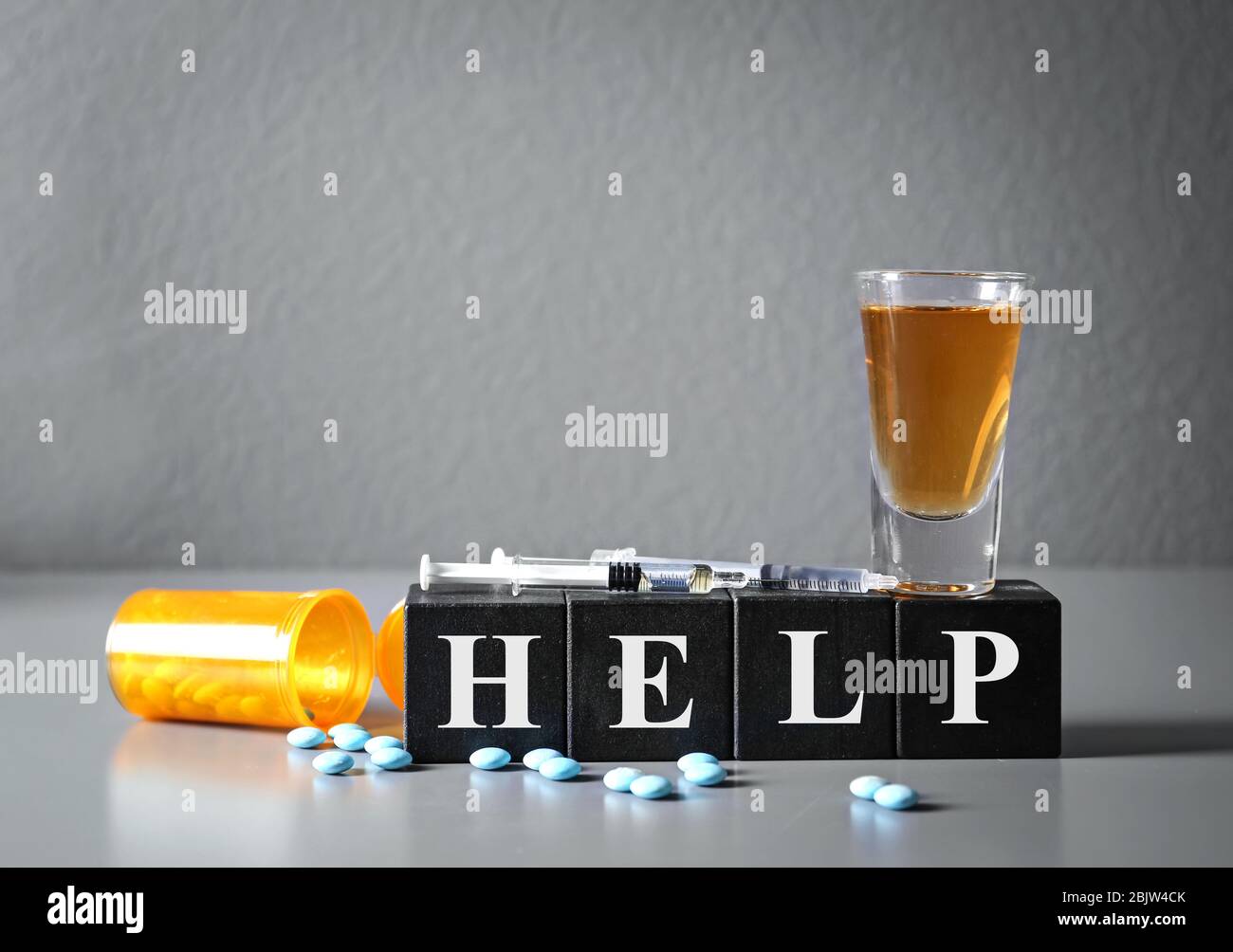 Starkes Getränk, Drogen und Würfel mit WORTHILFE auf dem Tisch. Konzept des  Alkoholismus Stockfotografie - Alamy