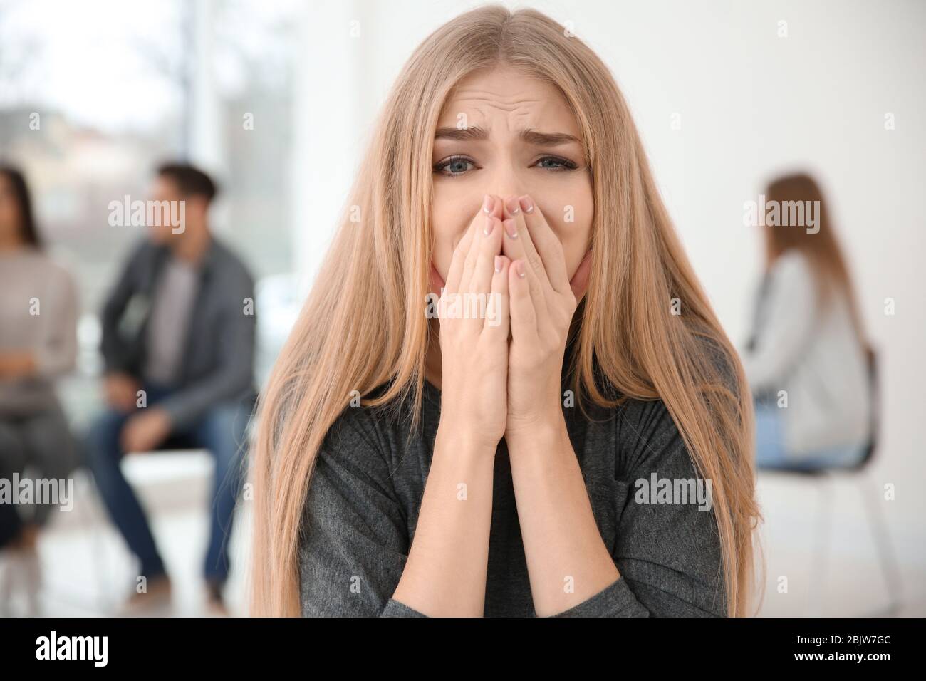 Betonte Frau während der gruppentherapie, innen Stockfoto
