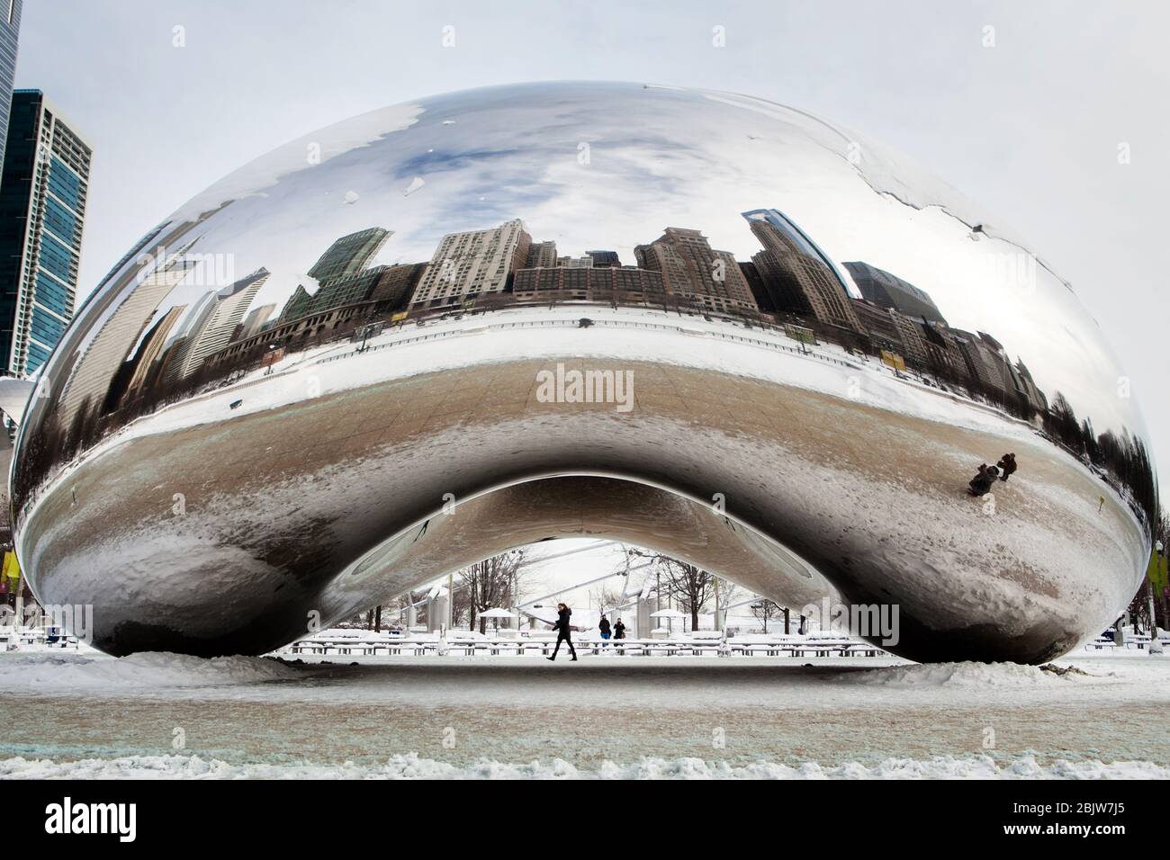 CHICAGO - 7. Januar: Das Cloud Gate, auch bekannt als die mit Schnee bedeckte Bohne, wird von Touristen gesehen. Die Skulptur ist eine berühmte Kunstinstallation lokalisieren Stockfoto