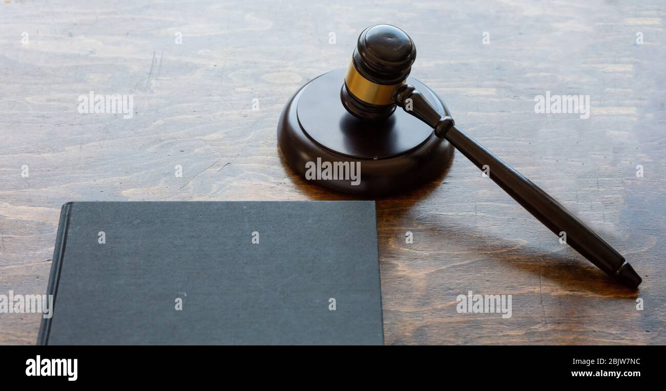 Thema „Recht“. Richter gavel und ein schwarzes leeres legales Buch auf hölzernen Schreibtisch Hintergrund, kopieren Raum. Auktion, Gerichtsstand Stockfoto