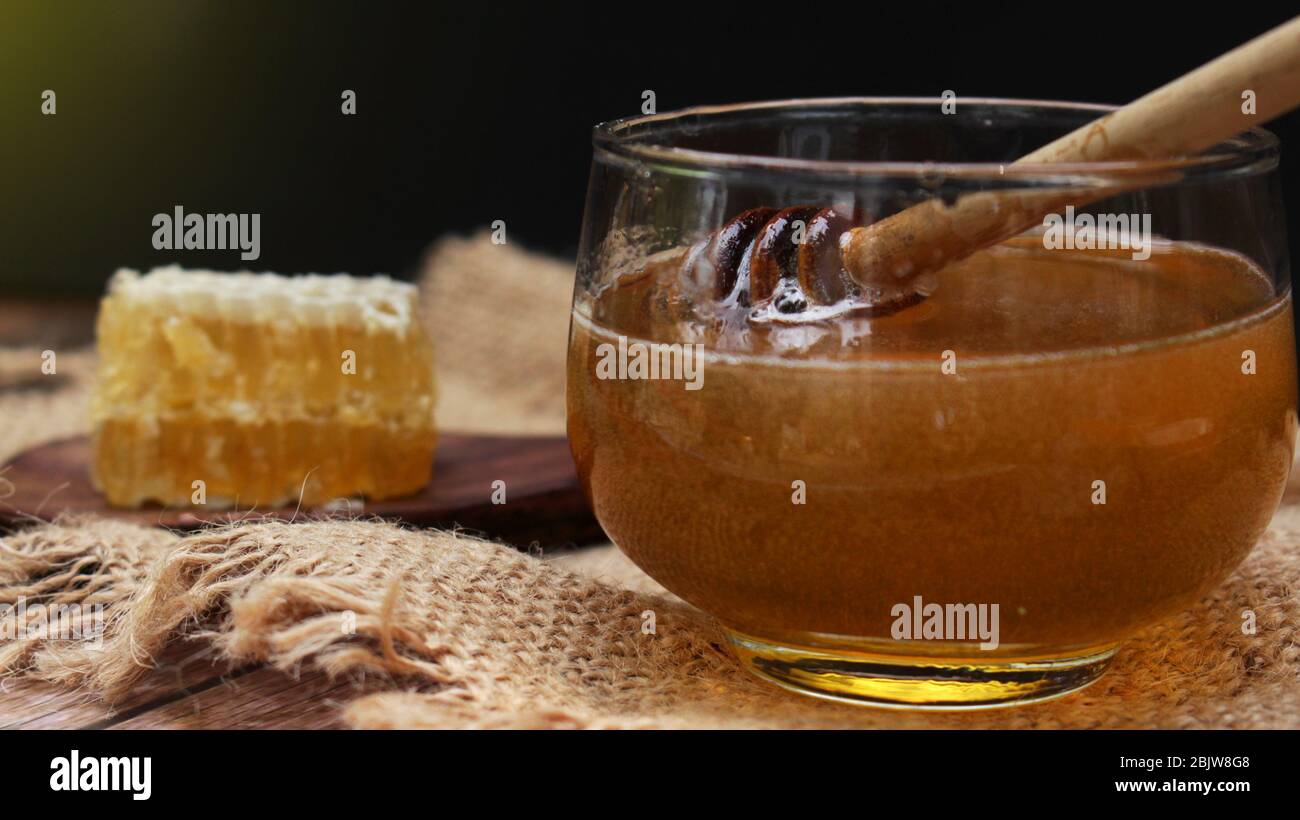 Honig ist gesund, mit einem Honiglöffel umrühren Stockfoto