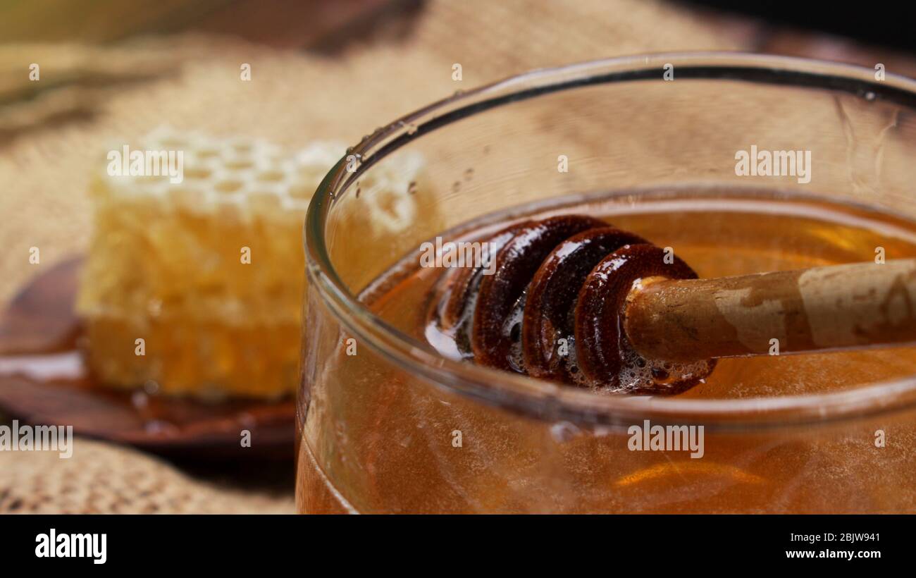 Honig ist gesund, mit einem Honiglöffel umrühren Stockfoto