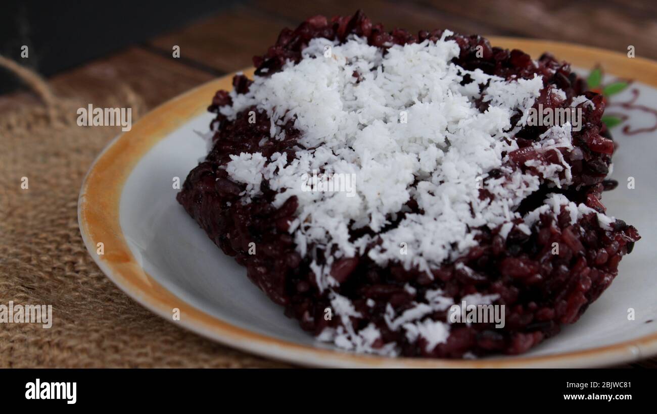 Schwarzer klebriger Reis oder Ketan Hitam (indonesischer Name) mit geriebener Kokosnuss, sehr lecker und süß Stockfoto