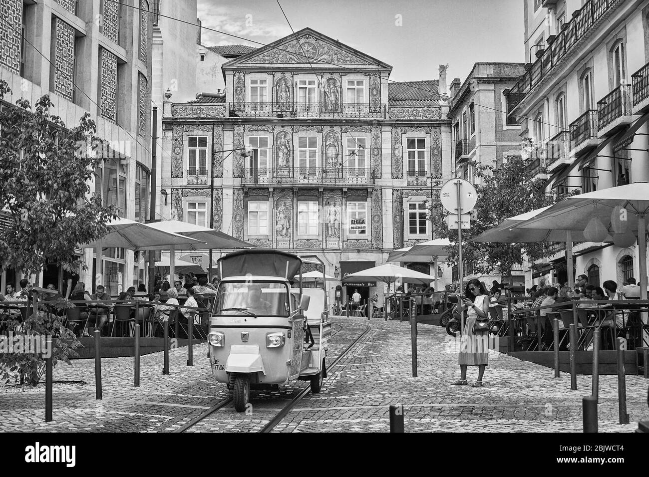 Ein Tuk-Tuk fährt durch einen plaza-Bereich der Altstadt von Lissabon, Portugal mit einer schönen Keramikfassade im Hintergrund Stockfoto