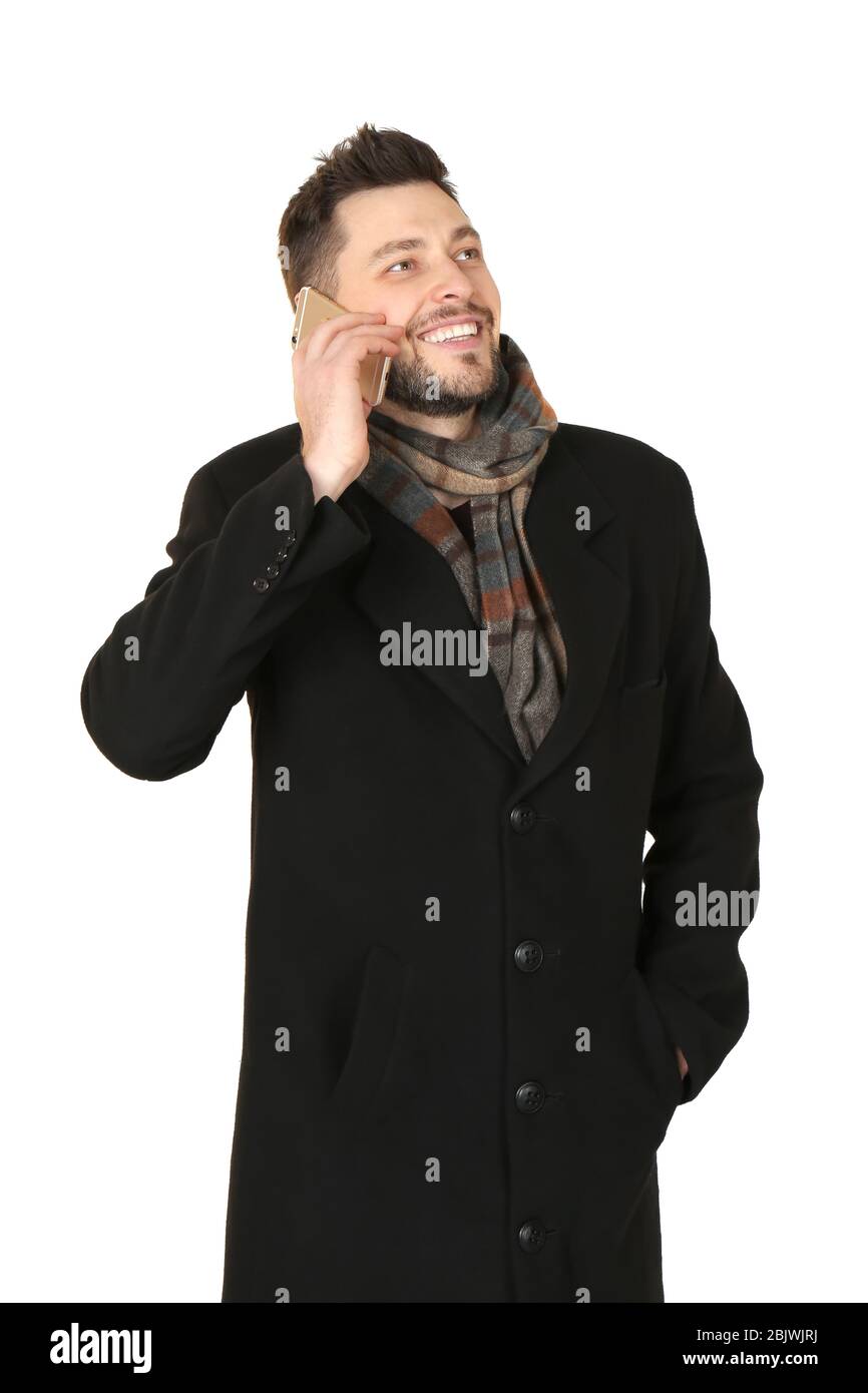 Junger Mann, der vor weißem Hintergrund telefoniert. Bereit für den Winterurlaub Stockfoto