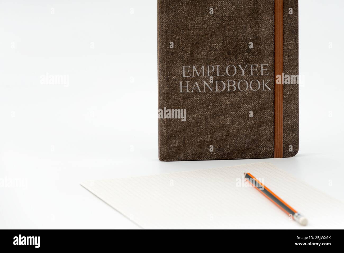 Mitarbeiterhandbuch oder Handbuch mit einem Stift und Papier auf einem weißen Tisch in einem Büro - Personalmanagement-Richtlinie, erläutert Geschäftsziele, Ergebnisse, definieren Stockfoto