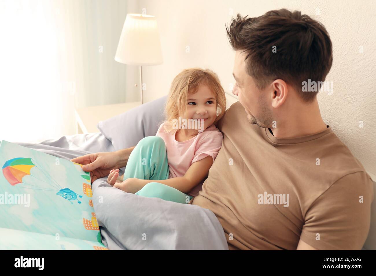 Vater mit kleiner Tochter liest Schlafenszeit Geschichte zu Hause  Stockfotografie - Alamy