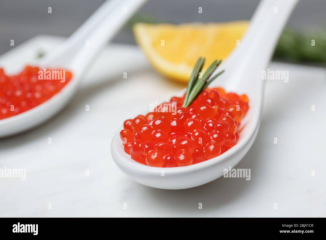 Löffel mit köstlichem roten Kaviar auf dem Tisch, Nahaufnahme Stockfoto