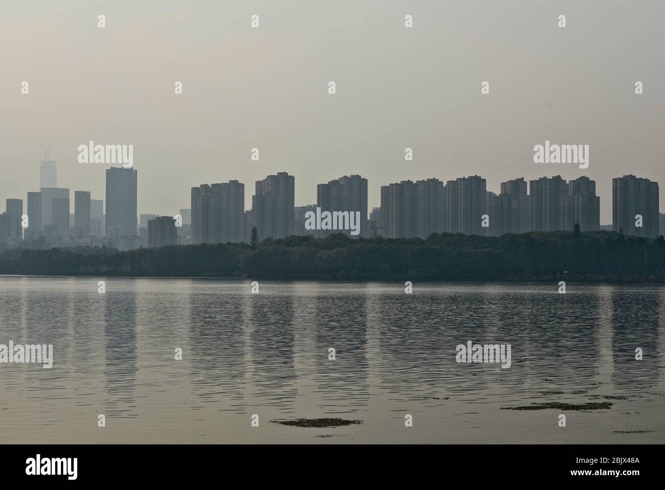 Skyline von Wuhan vom East Lake, mit Smog und einem nebligen Himmel aufgrund starker Verschmutzung. China Stockfoto