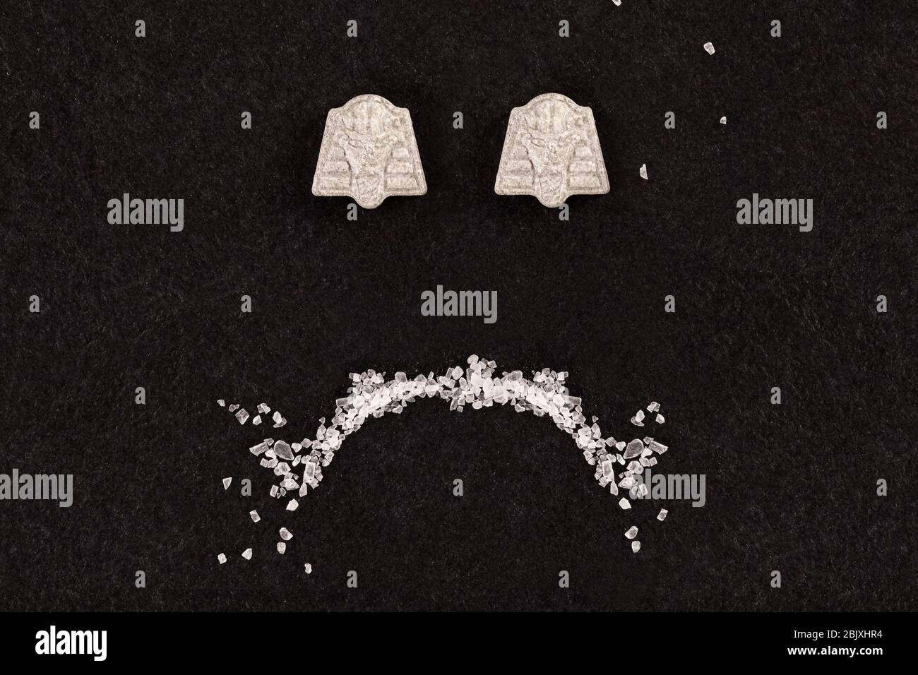 Drogenmissbrauch und sucht. MDMA Kristall und Ekstase Pille bilden ein trauriges Smiley. Depression. Stockfoto