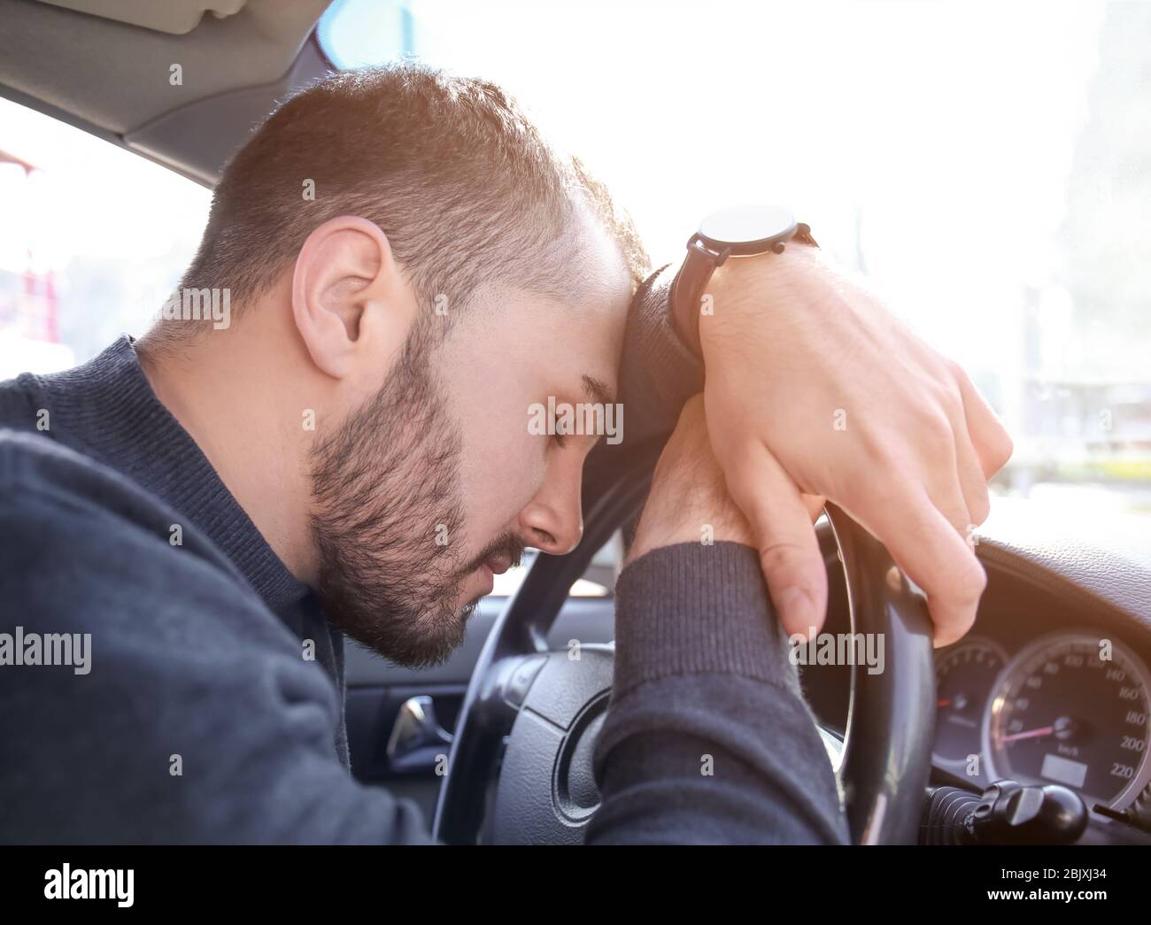 Junger Mann schläft im Auto während Stau Stockfoto