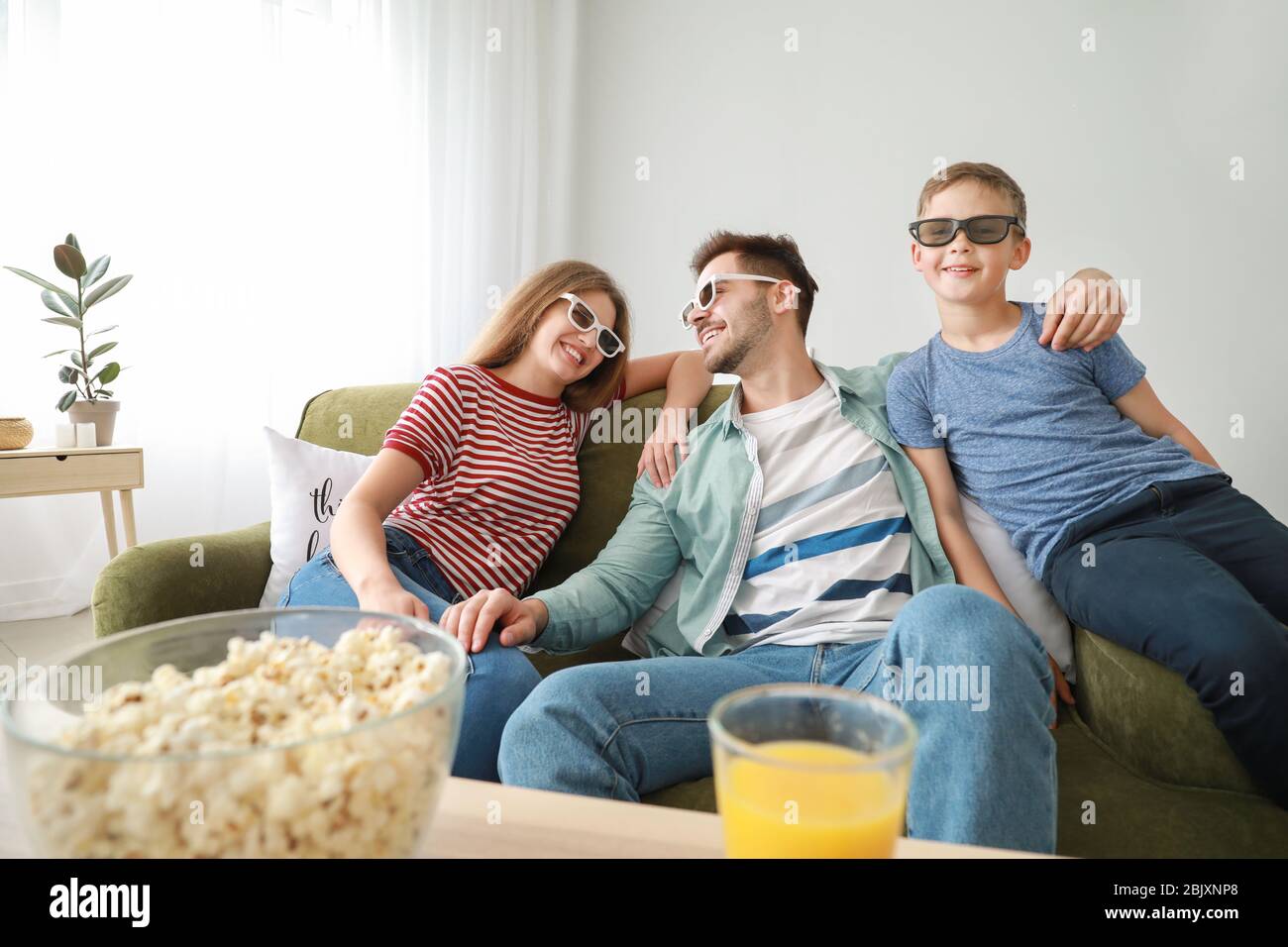 Glückliche Familie vor dem Fernseher zu Hause Stockfoto