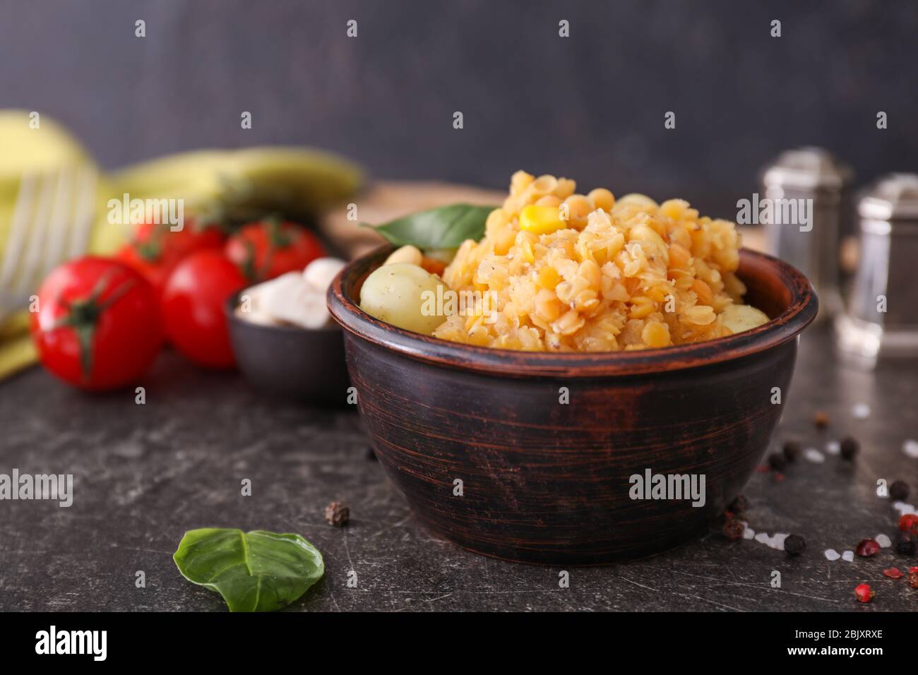 Schüssel mit gekochten Erbsen und Kartoffeln auf dunklen Tabelle Stockfoto