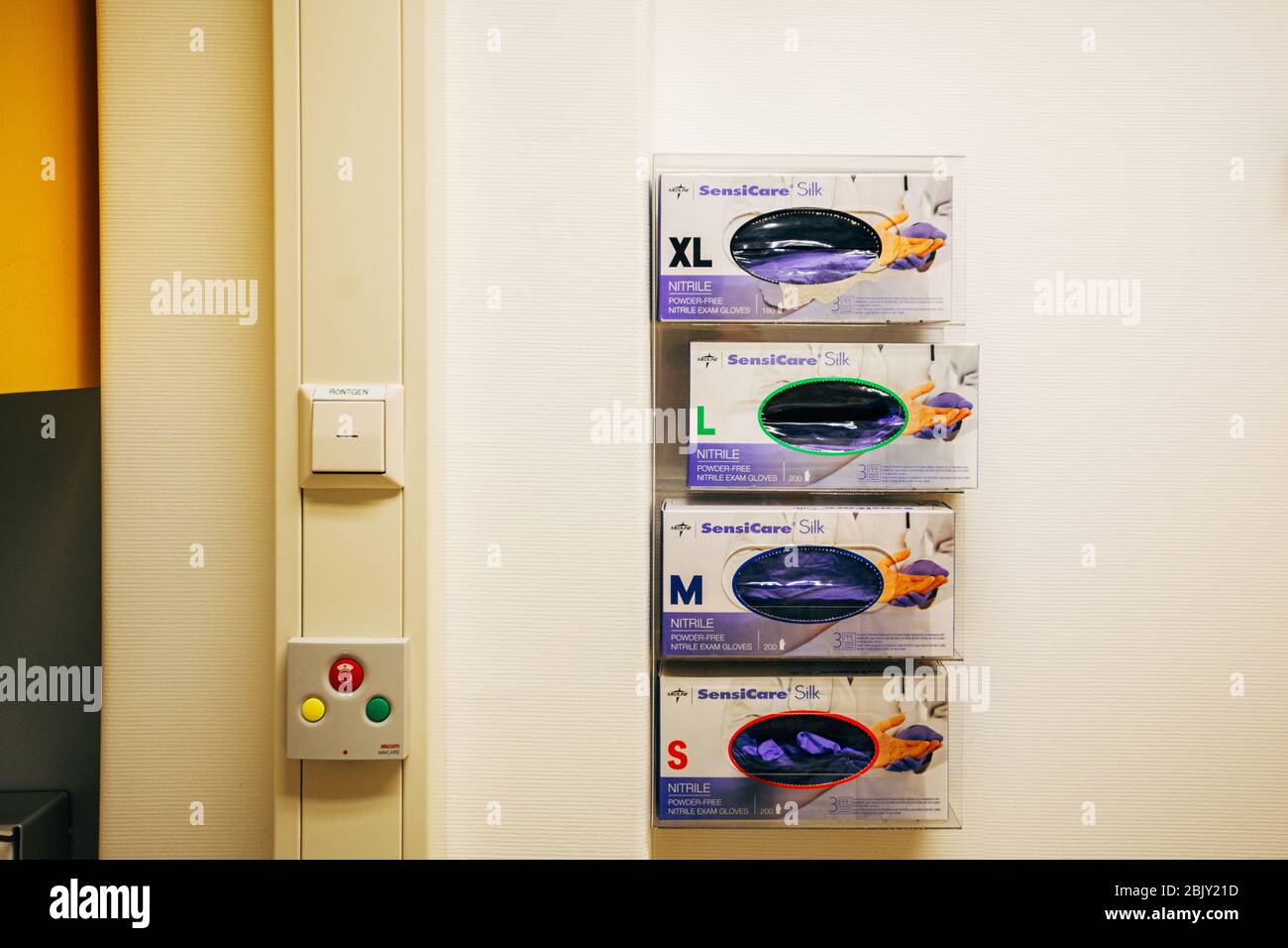 Einweghandschuhe an der Wand in der Notaufnahme im Krankenhaus in den Niederlanden montiert. Medizinische Schutzhandschuhe Stockfoto