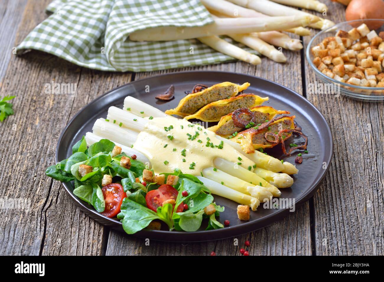 Weißer Spargel mit gebratenen gefüllten schwäbischen Fleischravioli serviert mit Maissalat mit Croutons Stockfoto