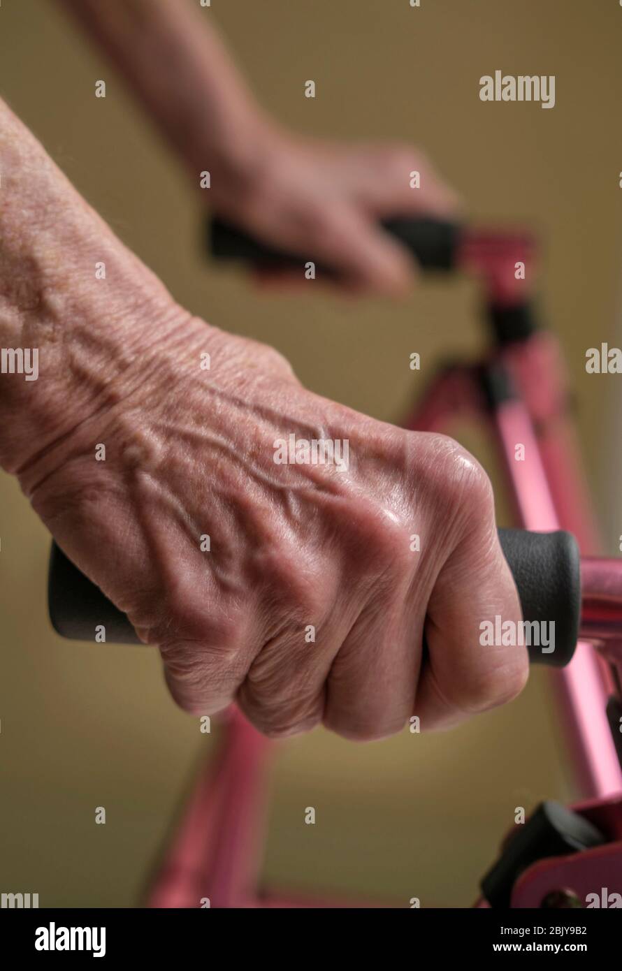 Nahaufnahme der Hände einer älteren Frau auf einem Gehwagen Stockfoto