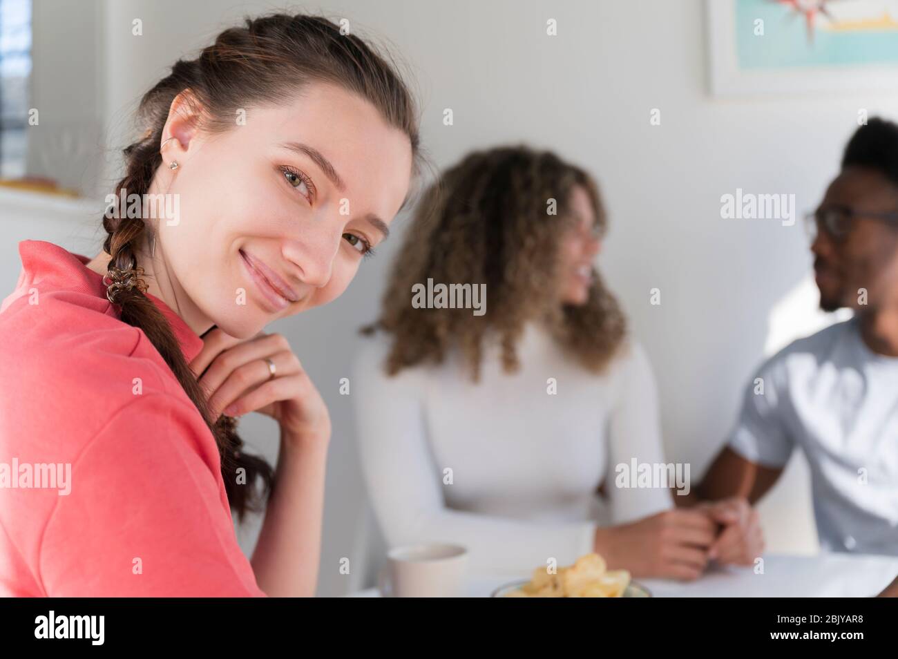 Frau lächelnd, während sie mit friendsÂ rumhängt Stockfoto
