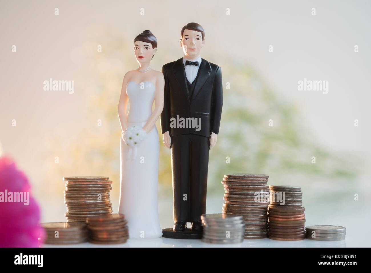 Braut und Bräutigam Kuchenauflagen neben Stapel von coinsÂ Stockfoto