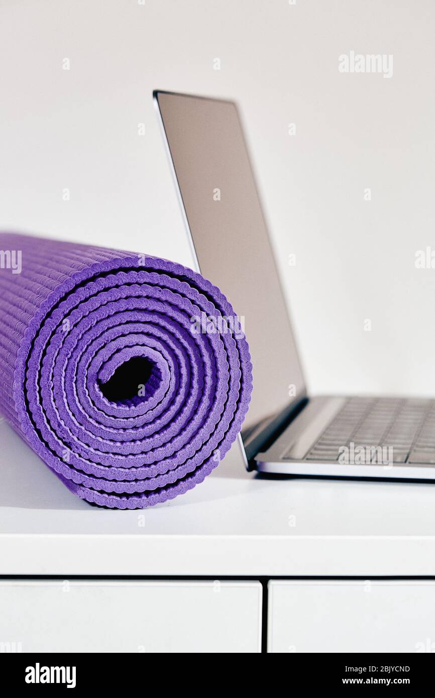 Yogamatte mit Laptop auf dem Tisch Stockfoto