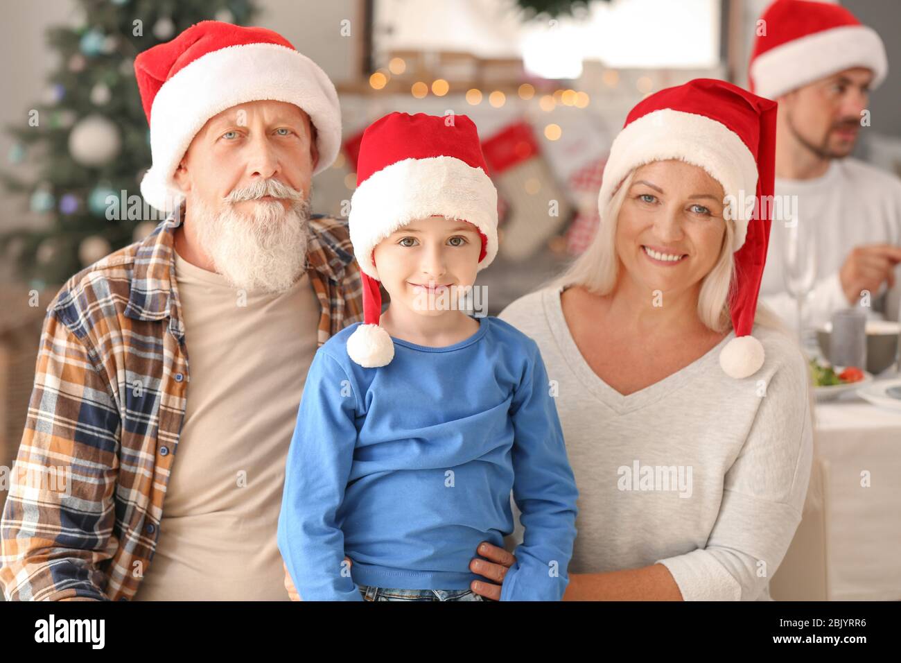 Glückliche Großeltern mit kleinen Jungen während der Weihnachtsfeier zu Hause Stockfoto