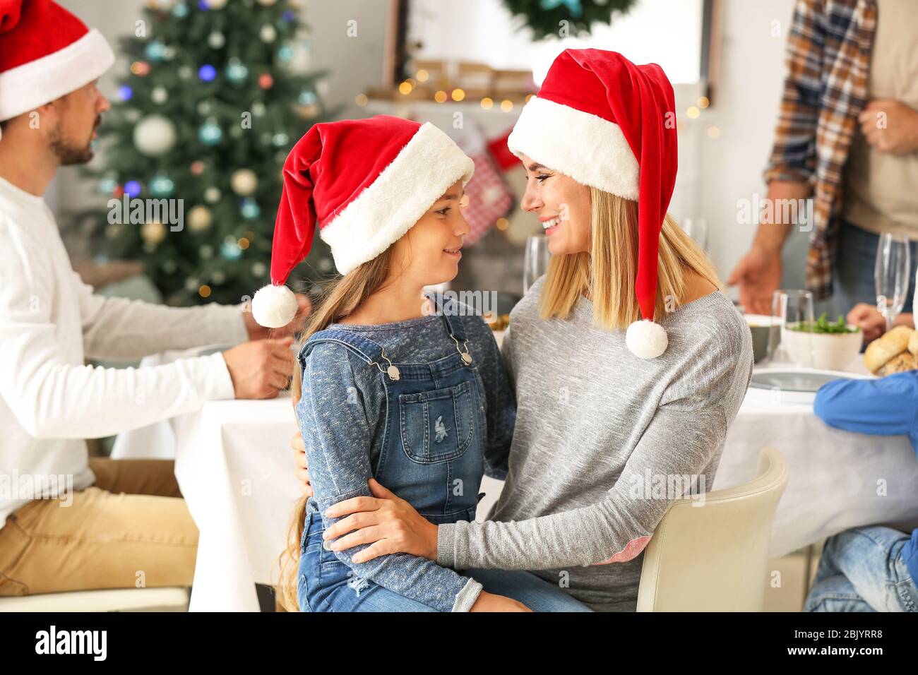 Glückliche Mutter mit Tochter während der Weihnachtsfeier zu Hause Stockfoto