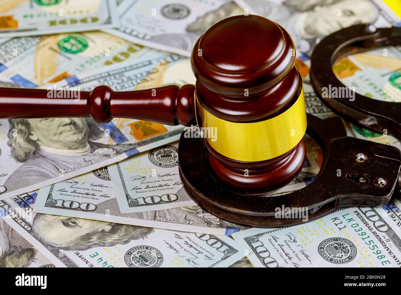 Hölzerner Richtergabel mit Handschellen auf Sicht von hundert US-Dollar-Scheinen vor Gericht Stockfoto