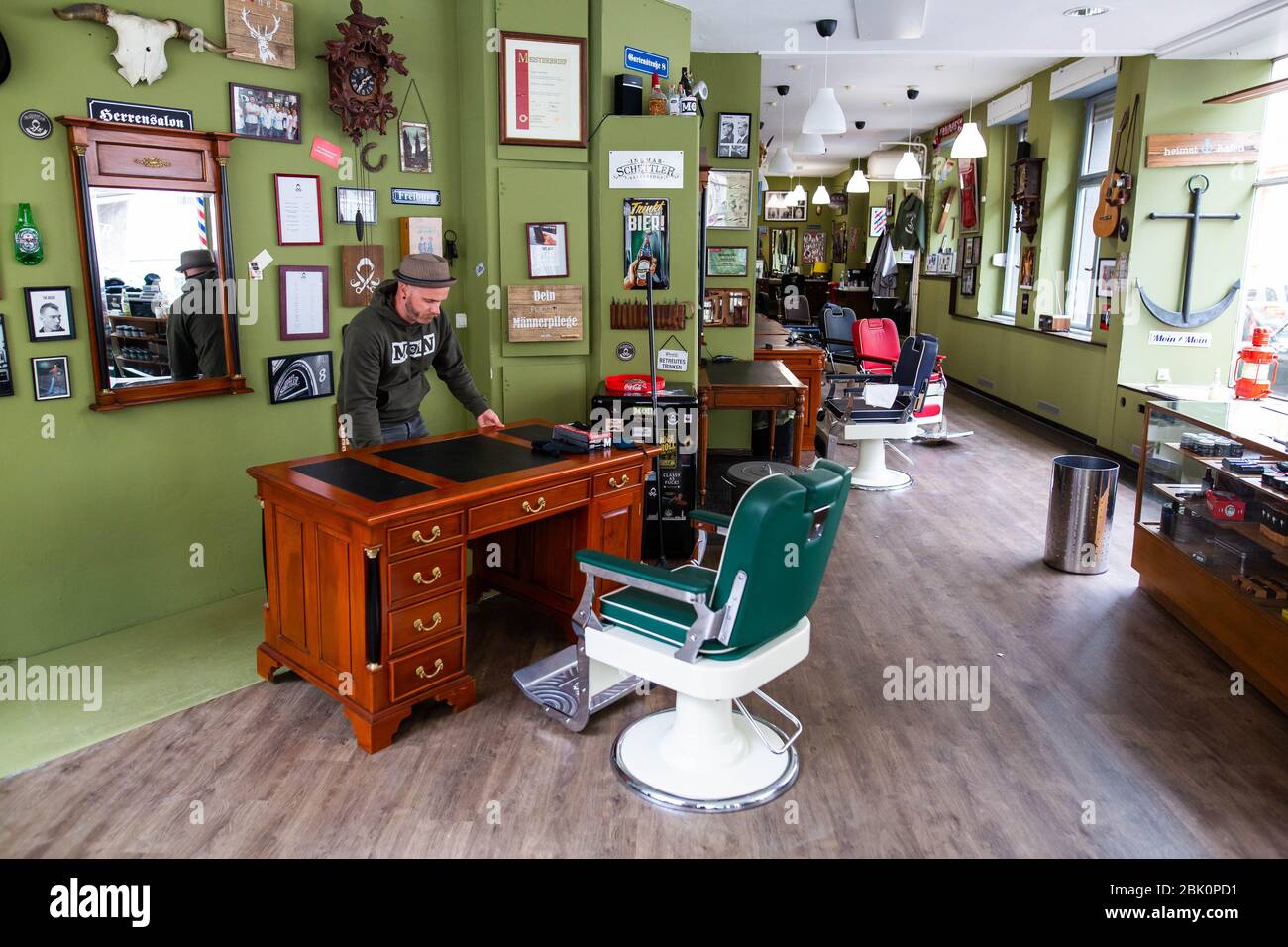 Freiburg Im Breisgau, Deutschland. April 2020. Friseur Ingmar Schettler bewegt einen Tisch zur Seite, um einen minimalen Abstand zwischen seinen Kunden zu gewährleisten. Friseure können ab dem 4. Mai unter bestimmten Bedingungen wieder geöffnet werden. So dürfen beispielsweise keine Zeitschriften ausgestellt werden und Friseure müssen Handschuhe tragen. Quelle: Philipp von Ditfurth/dpa/Alamy Live News Stockfoto